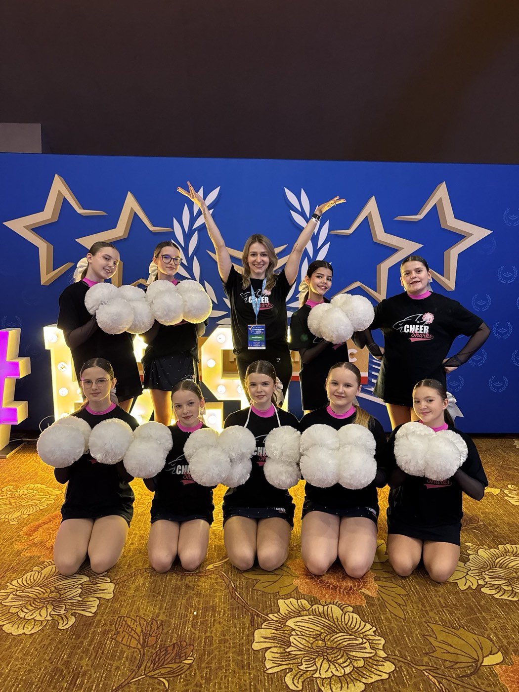 Drużyna Cheer Sharks z trenerami podczas zajęć w sali